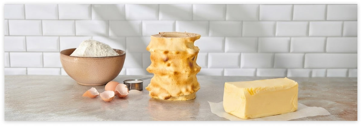 Baumkuchen ohne Überzug mit sichtbaren Schichten neben einem Butterstück